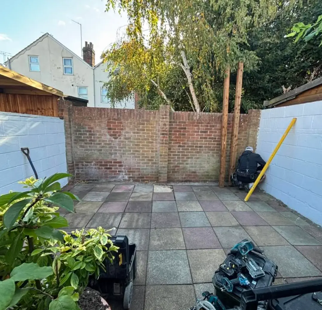 CWS carpenter setting timber posts in a courtyard garden