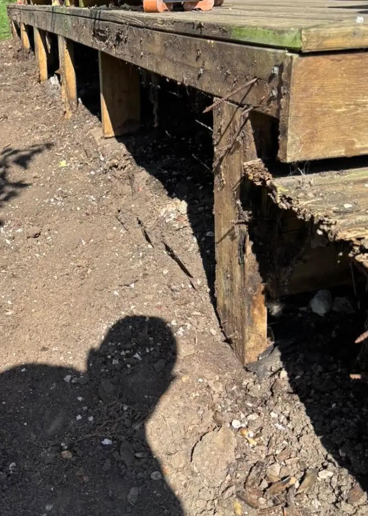 Old garden decking with rotten posts and frame