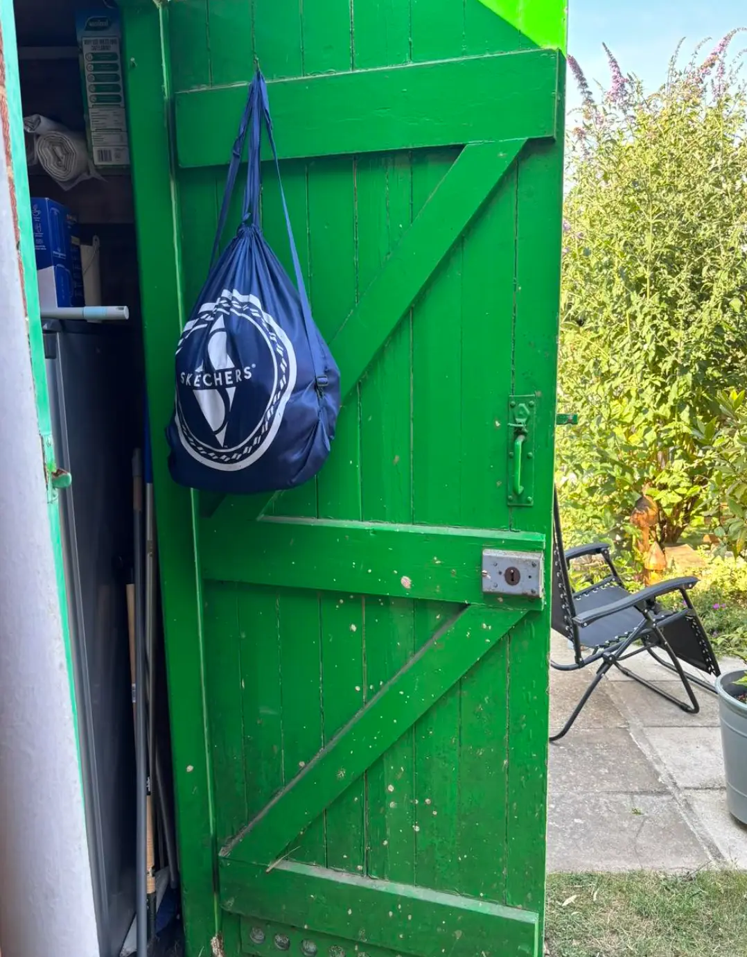 Weathered shed door with rot along the bottom rail