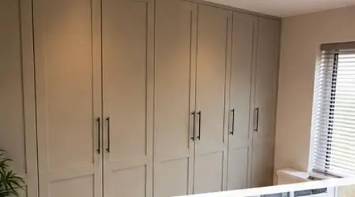 Fitted shaker-style wardrobes built wall to wall